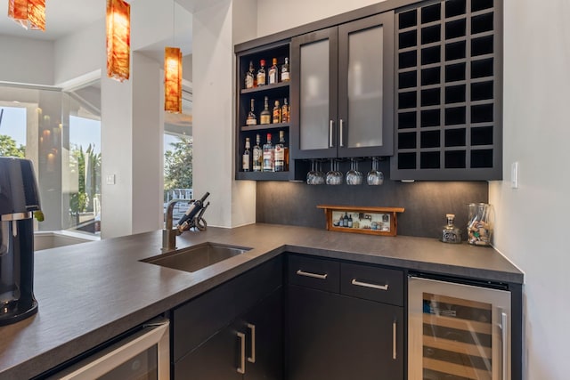 bar featuring sink, dishwasher, beverage cooler, decorative light fixtures, and decorative backsplash