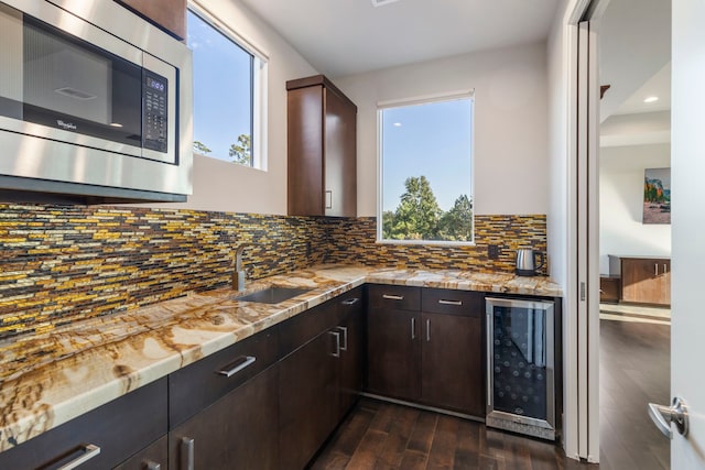 kitchen featuring wine cooler, dark brown cabinetry, stainless steel microwave, and dark hardwood / wood-style floors