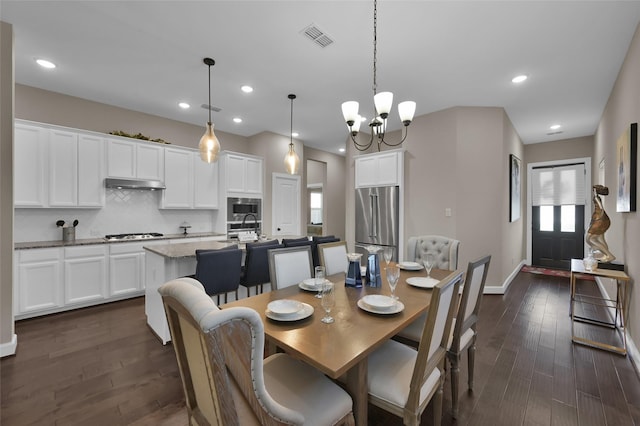 dining room featuring dark hardwood / wood-style flooring, sink, and a chandelier