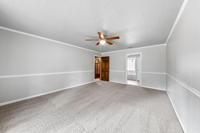 carpeted empty room with ceiling fan, crown molding, and a textured ceiling