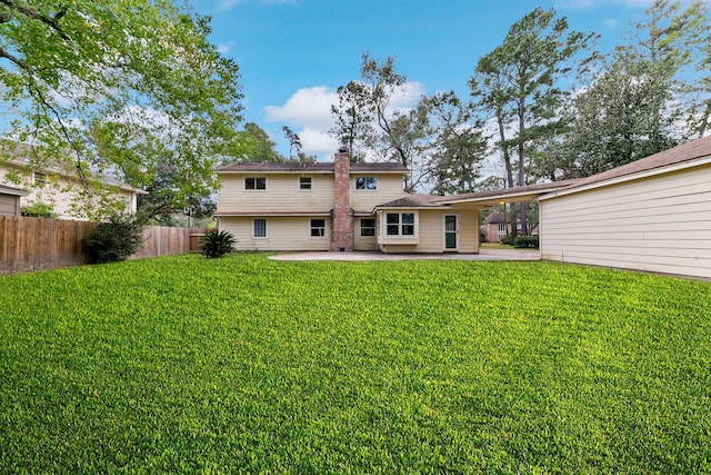 rear view of property with a lawn and a patio