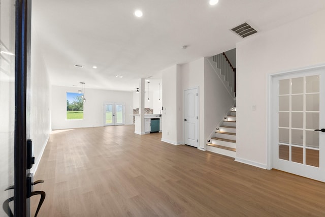 unfurnished living room with french doors and light hardwood / wood-style flooring