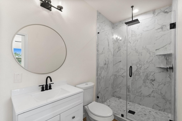 bathroom with vanity, a shower with shower door, and toilet