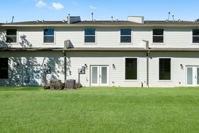 rear view of property featuring central air condition unit, a yard, and french doors