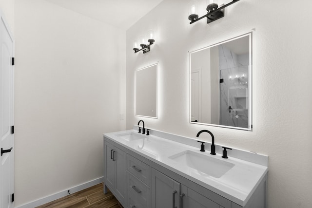 bathroom featuring hardwood / wood-style flooring, vanity, and walk in shower