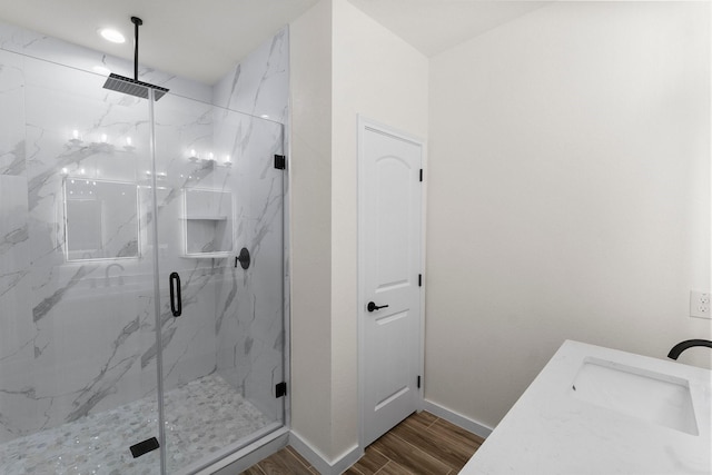 bathroom featuring hardwood / wood-style floors, a shower with shower door, and sink