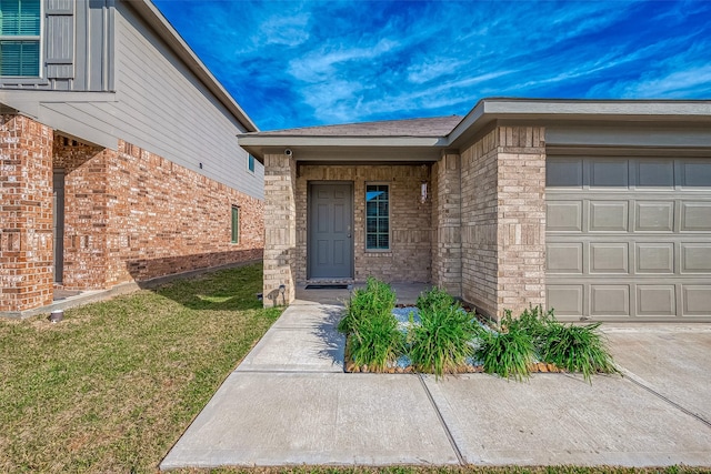 view of exterior entry with a yard and a garage