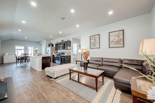 living room featuring light hardwood / wood-style flooring and lofted ceiling