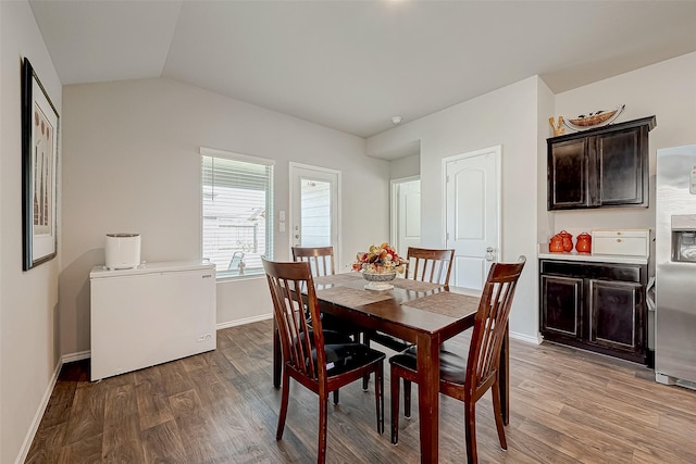 dining room with hardwood / wood-style floors and lofted ceiling