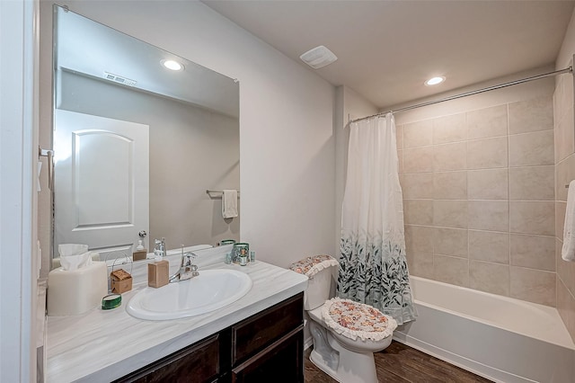 full bathroom featuring hardwood / wood-style flooring, shower / bath combination with curtain, toilet, and vanity