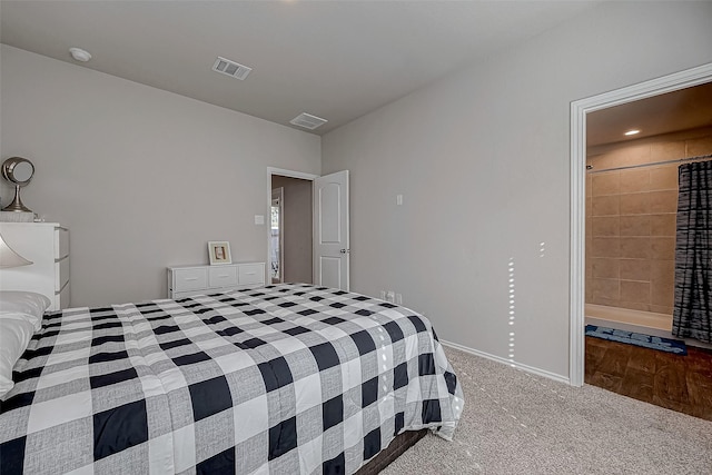 bedroom with connected bathroom and light carpet