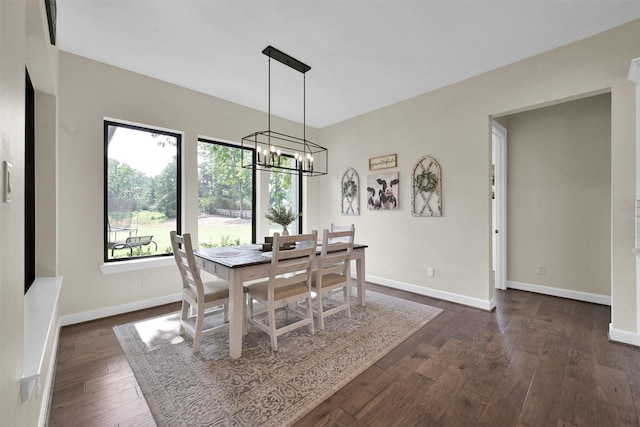 dining room with dark hardwood / wood-style floors and an inviting chandelier