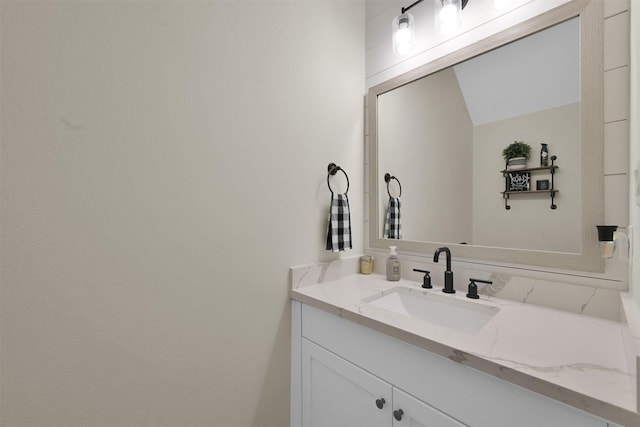 bathroom with vanity and lofted ceiling