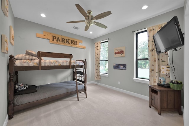 carpeted bedroom featuring ceiling fan and multiple windows