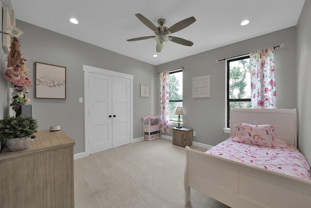 carpeted bedroom featuring ceiling fan and a closet