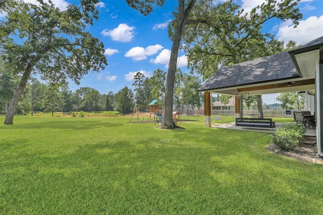 view of yard with ceiling fan and a playground