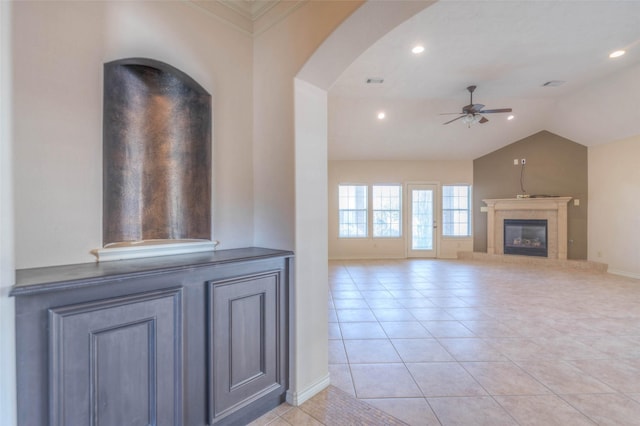 unfurnished living room with vaulted ceiling, light tile patterned floors, and ceiling fan