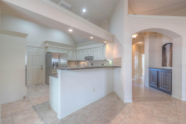 kitchen with sink, crown molding, white cabinetry, stainless steel fridge with ice dispenser, and kitchen peninsula