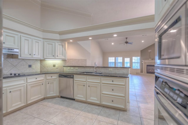 kitchen with sink, cream cabinetry, kitchen peninsula, and appliances with stainless steel finishes