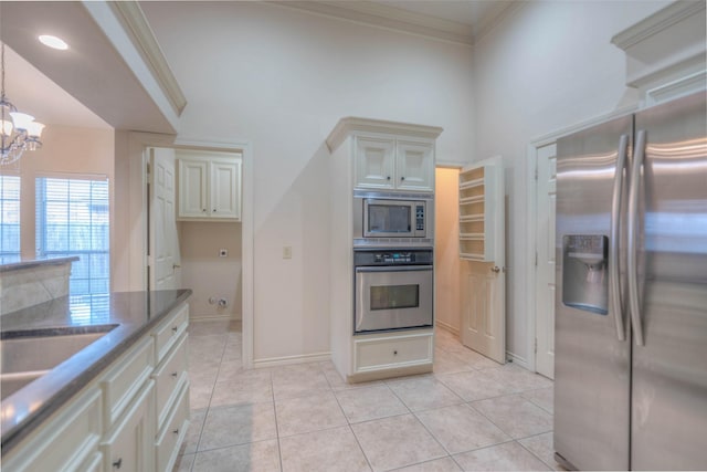 kitchen featuring ornamental molding, stainless steel appliances, cream cabinets, and light tile patterned floors