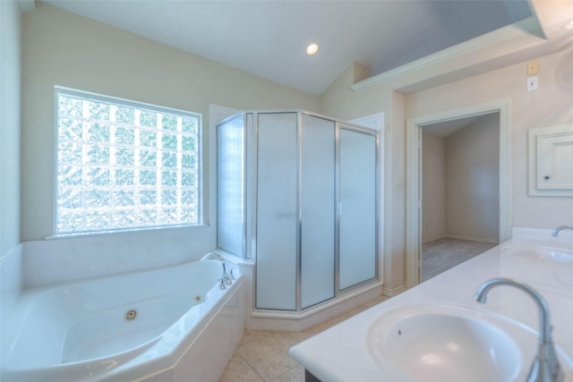 bathroom featuring tile patterned flooring, vanity, lofted ceiling, and a bath