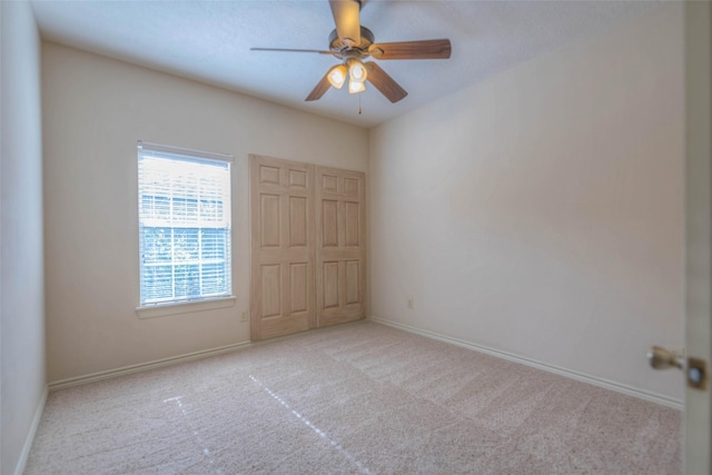 unfurnished bedroom featuring light colored carpet and ceiling fan