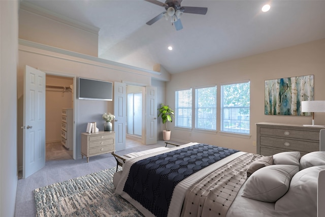 bedroom featuring ceiling fan, light colored carpet, lofted ceiling, and a spacious closet