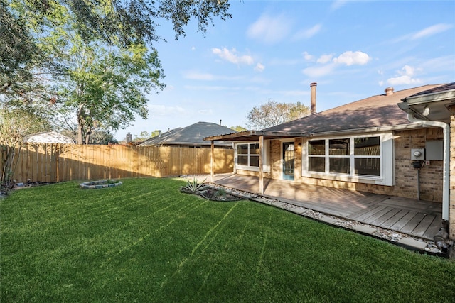 rear view of property with a wooden deck and a lawn