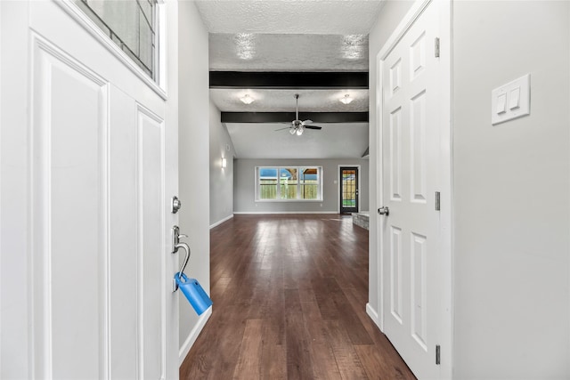 hallway with a textured ceiling, lofted ceiling with beams, and dark wood-type flooring