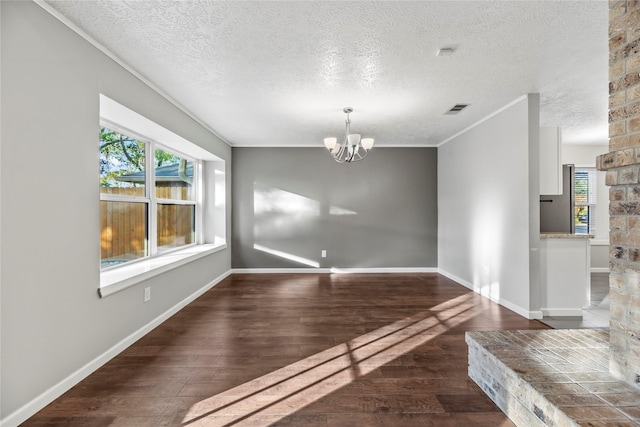 unfurnished dining area featuring dark hardwood / wood-style floors, a textured ceiling, and an inviting chandelier