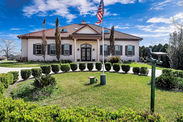 mediterranean / spanish house featuring a front yard and french doors