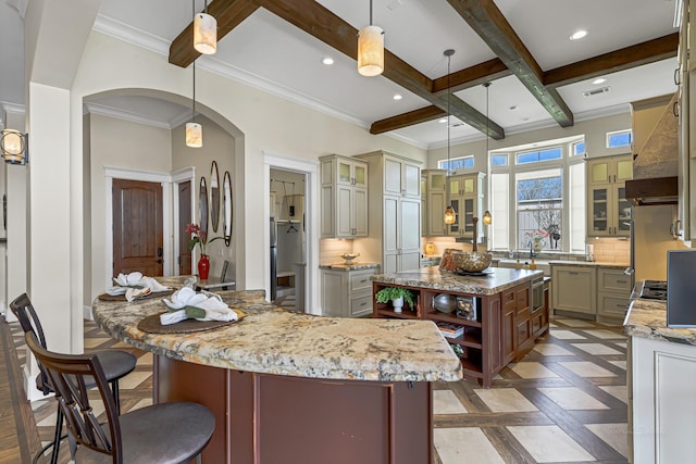 kitchen featuring backsplash, decorative light fixtures, and a kitchen island