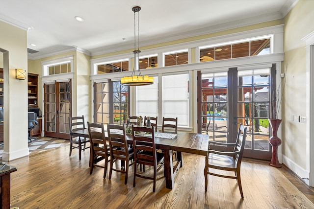 dining space with french doors, ornamental molding, and hardwood / wood-style flooring