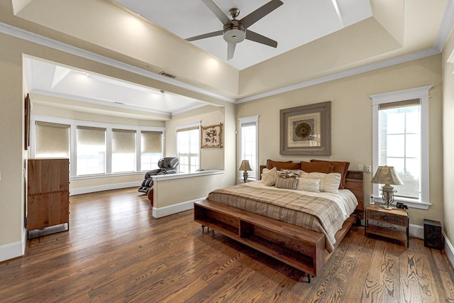 bedroom with ceiling fan, a raised ceiling, dark wood-type flooring, and multiple windows