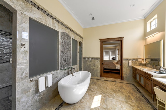 bathroom featuring a bath, vanity, tile walls, and crown molding