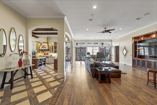 living room with beam ceiling, crown molding, ceiling fan, and dark hardwood / wood-style floors