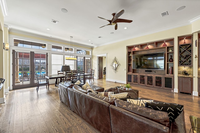 living room featuring crown molding, ceiling fan, and hardwood / wood-style flooring