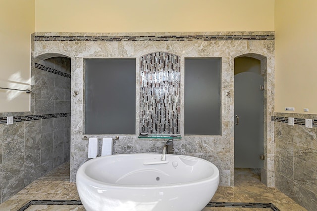 bathroom featuring a bath and tile walls