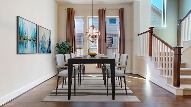 dining area featuring dark hardwood / wood-style flooring and an inviting chandelier