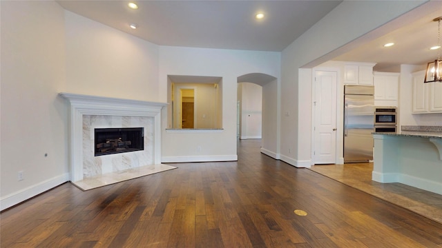 unfurnished living room featuring a fireplace, wood-type flooring, and a chandelier