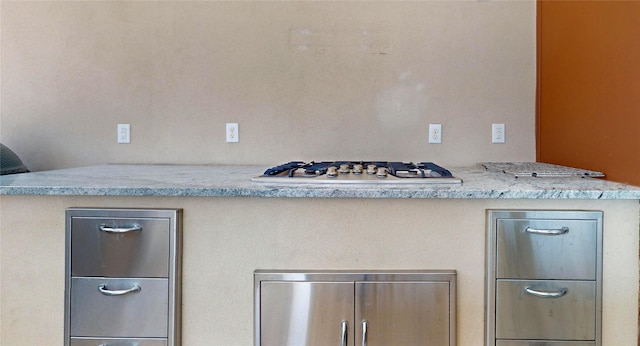 kitchen featuring stainless steel gas stovetop and light stone countertops