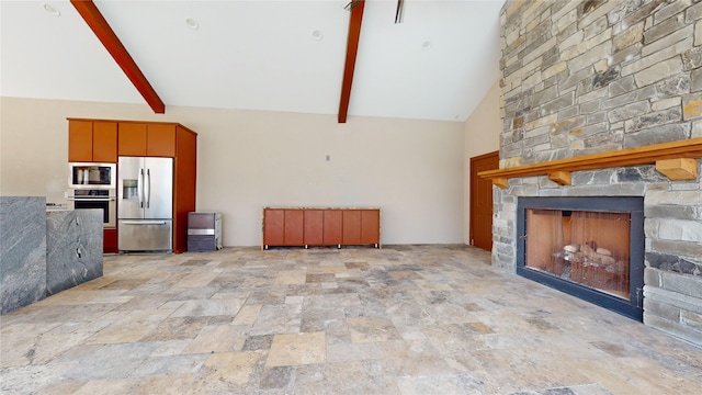 unfurnished living room with beam ceiling, a stone fireplace, and high vaulted ceiling