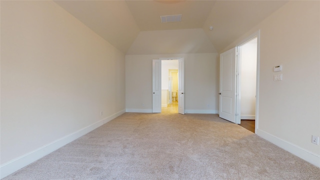 unfurnished bedroom with light carpet and lofted ceiling