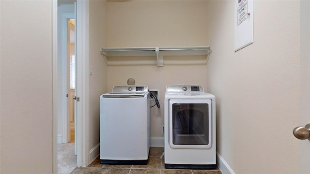 laundry room featuring dark tile patterned flooring and separate washer and dryer