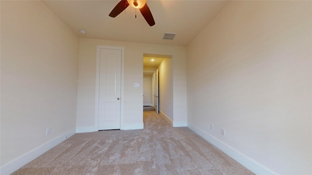 empty room with light colored carpet and ceiling fan