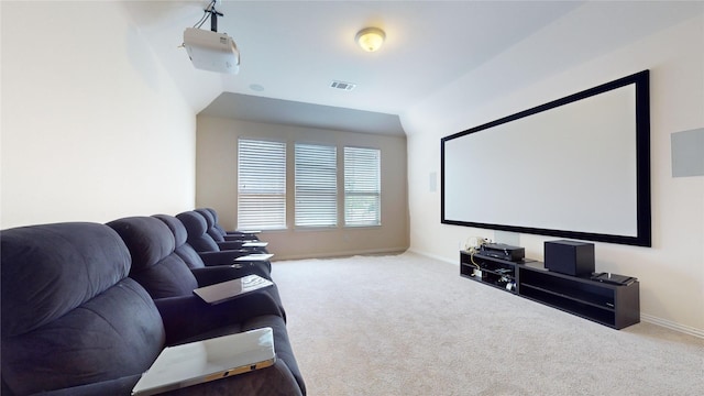 carpeted cinema room featuring vaulted ceiling