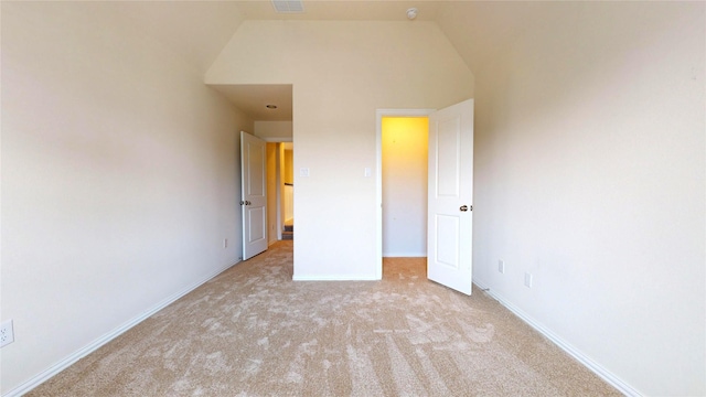 unfurnished bedroom featuring light carpet and vaulted ceiling