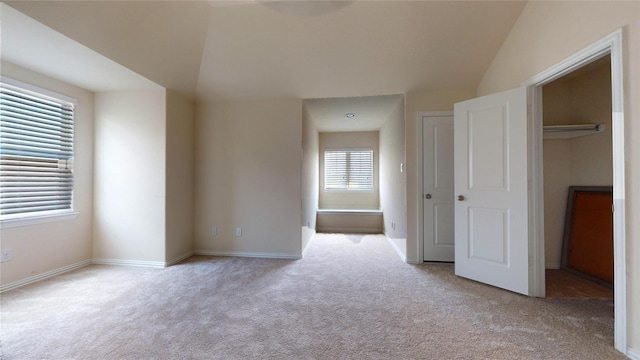 spare room featuring lofted ceiling and light carpet