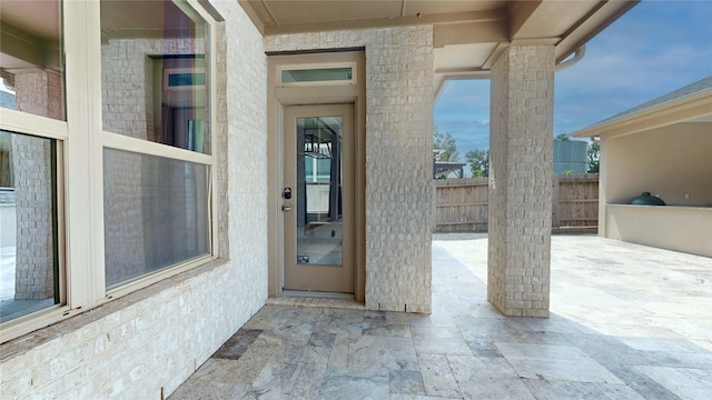 view of exterior entry with a patio