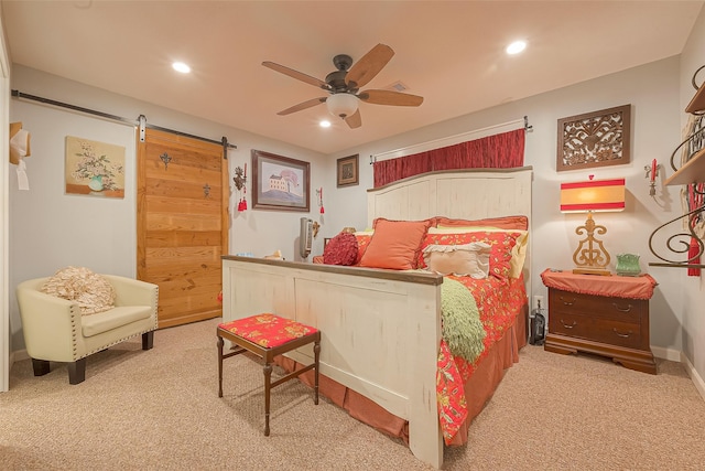 carpeted bedroom featuring a barn door and ceiling fan